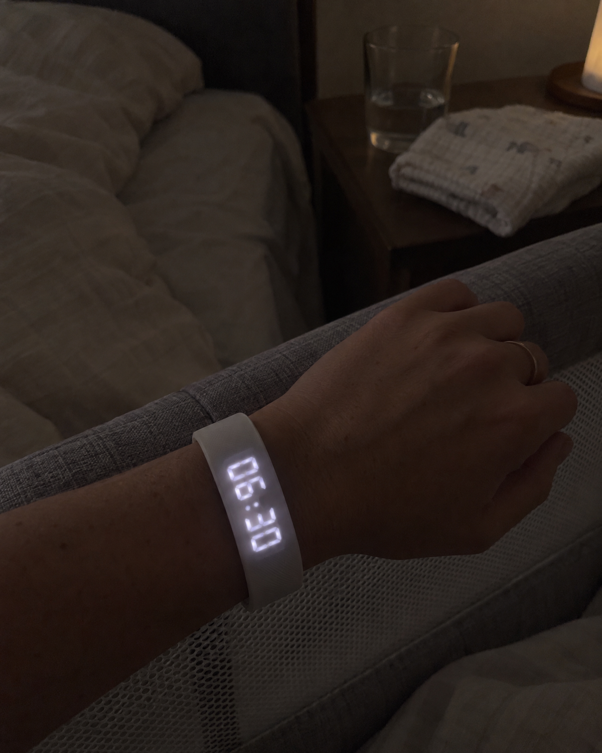 Nemi showing 06:30 on a wrist resting on the rail of a bedside bassinet